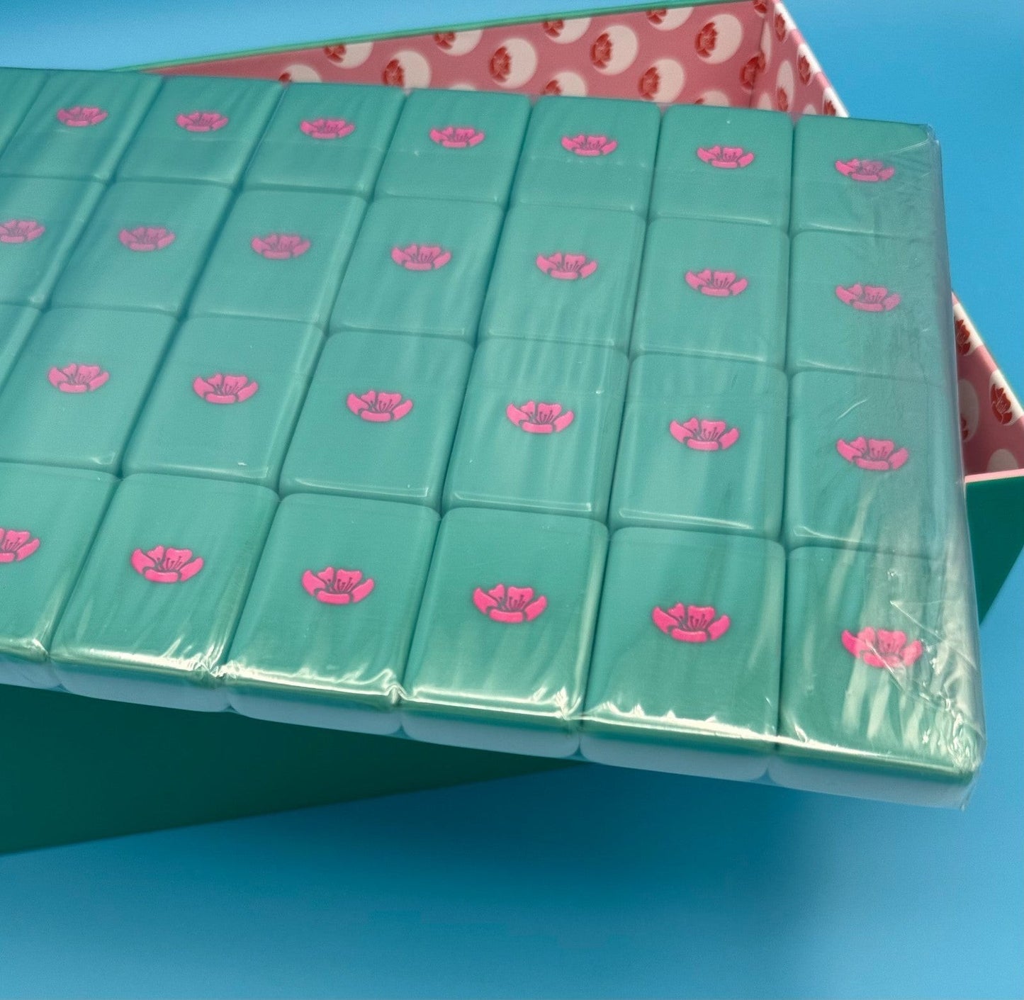 Luxury Mahjong teal house tiles with pink flower engravings in a decorative patterned storage box.