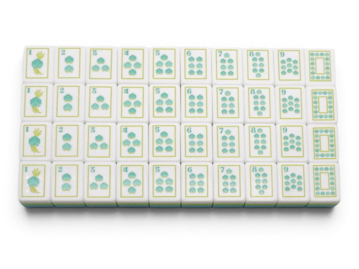 The Sea Glass Pearl American Mahjong tiles with a hand-illustrated hummingbird motif in teal, sage and antique gold