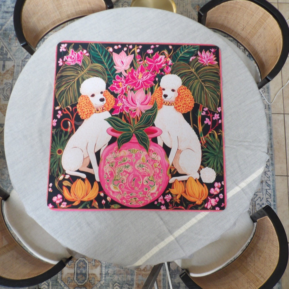 Black mahjong mat with two white poodles flanking a pink ginger jar of orchids and monstera leaves