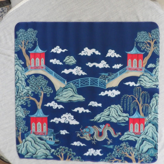 Navy blue chinoiserie mahjong mat with red pagodas, arched bridges, willow trees and a dragon in the clouds