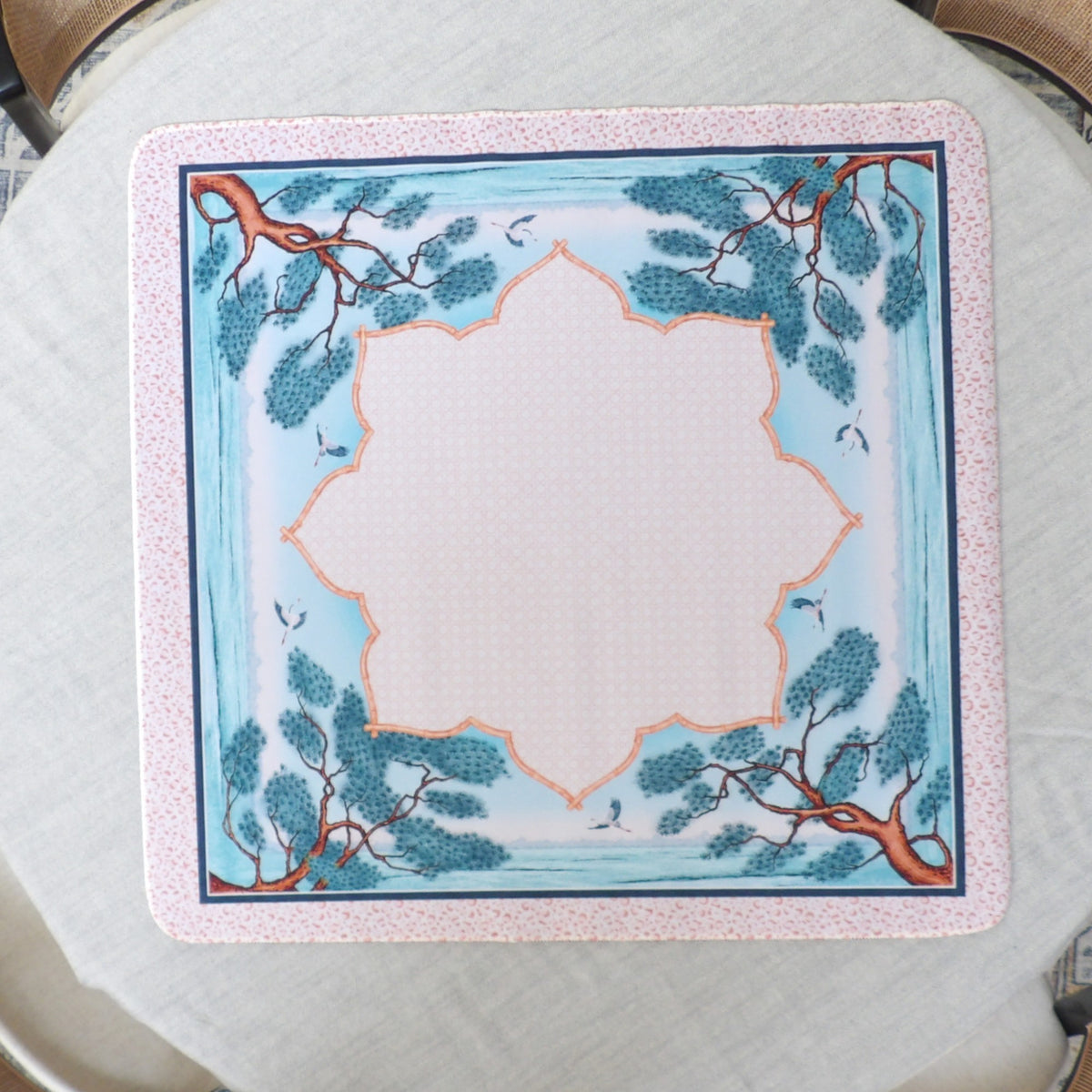 Pale blue chinoiserie mahjong mat with windswept pine trees, cranes and an orange bamboo cartouche border