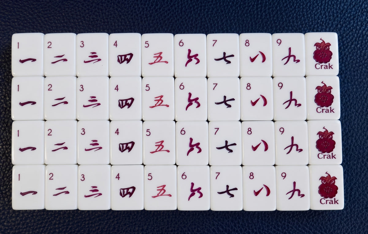 Luxury Mahjong Blue Willow set featuring white acrylic tiles with deep burgundy Crak suit numbers and peacock icons.