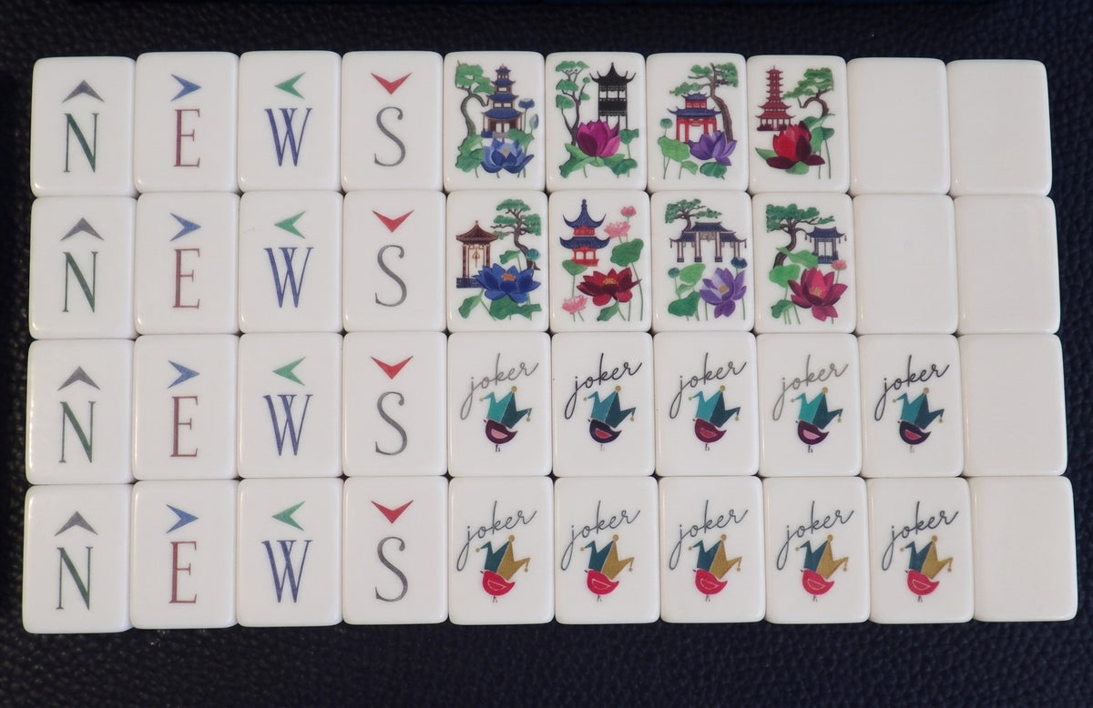 Luxury Mahjong Blue Willow set featuring etched acrylic tiles with NEWS, floral pagoda, and joker designs.