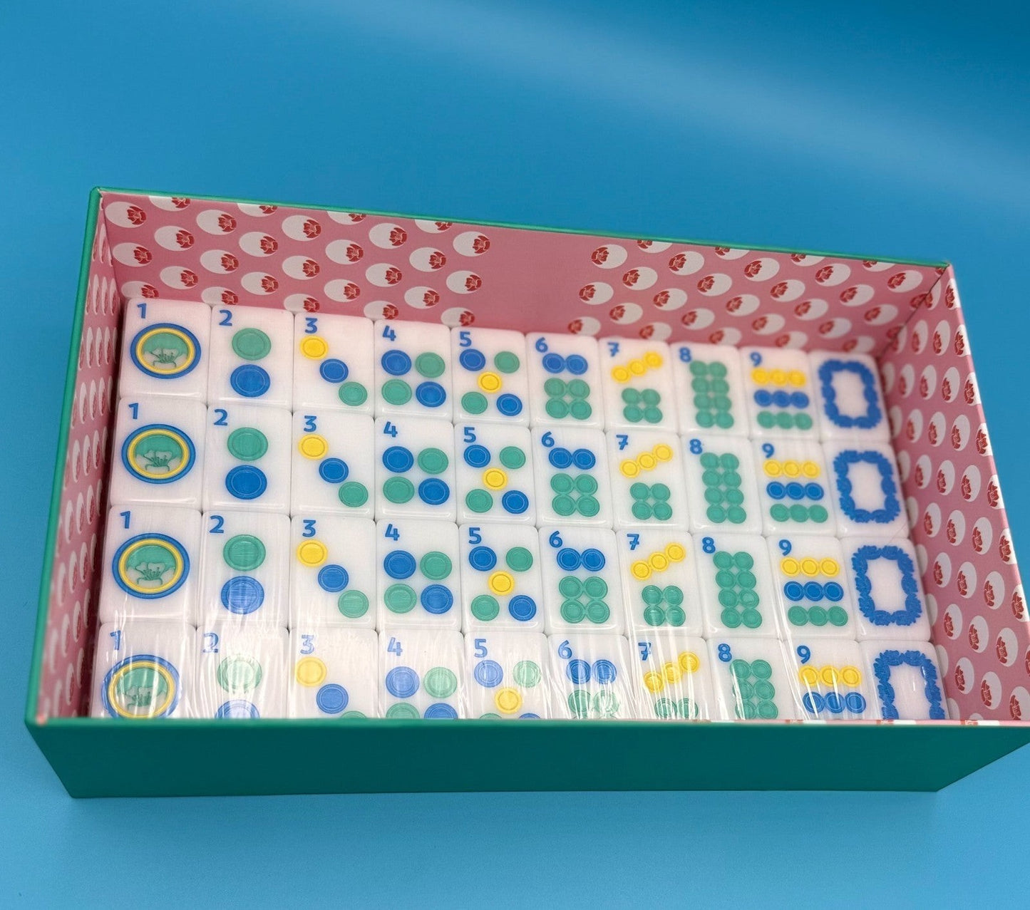 Luxury Mahjong The Brights! teal house tiles set in a decorative pink and white patterned storage box.