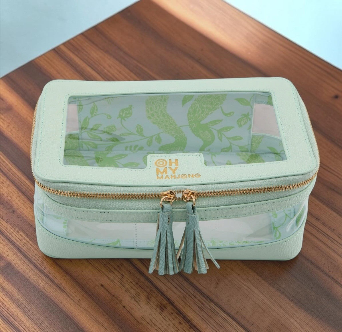 Luxury Mahjong mint storage case with clear panels, gold hardware, tassel pulls, and green peacock toile lining.