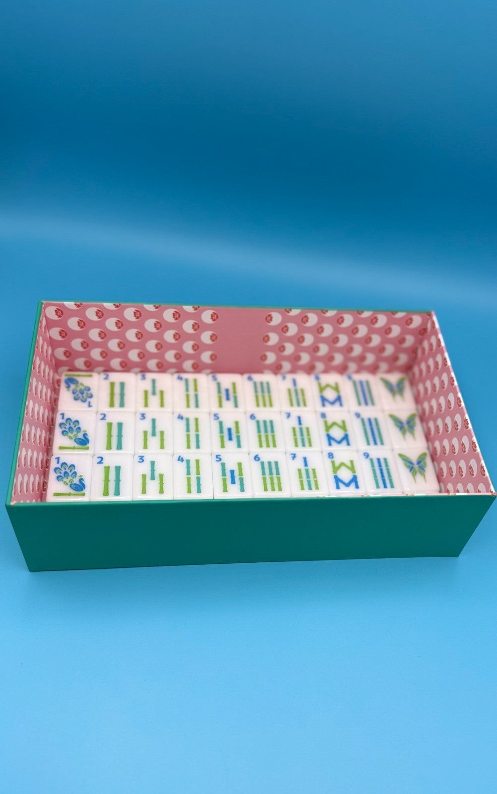 Luxury Mahjong The Brights! teal house tiles with colorful peacock, bamboo, and butterfly designs in a patterned box.