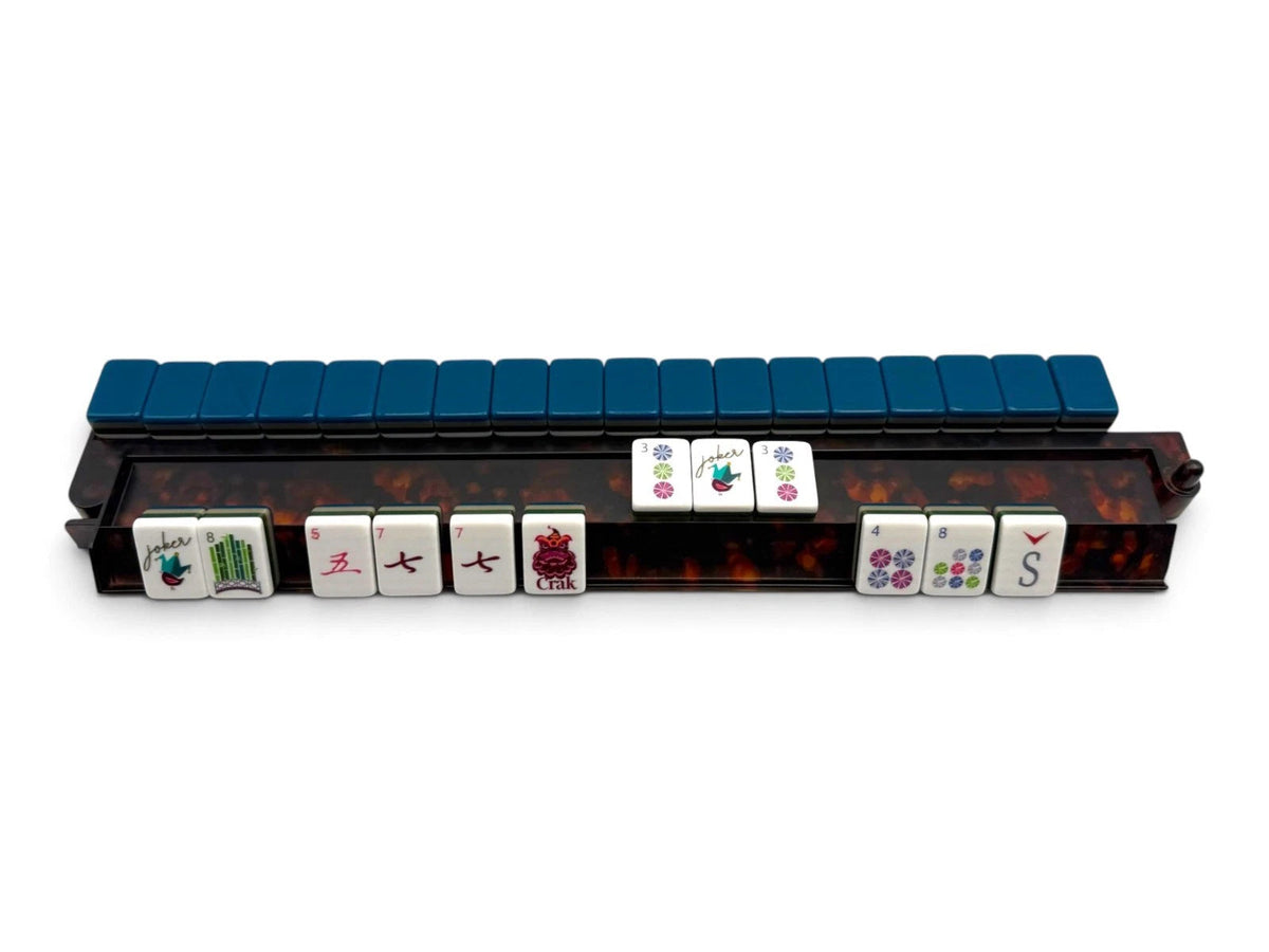 Luxury Mahjong tortoiseshell acrylic rack with hinged pusher holding a row of mahjong tiles on a white background